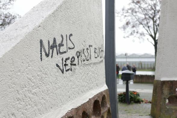 Mahnmal mit einem Graffiti mit der Aufschrift "Nazis verpisst euch!"