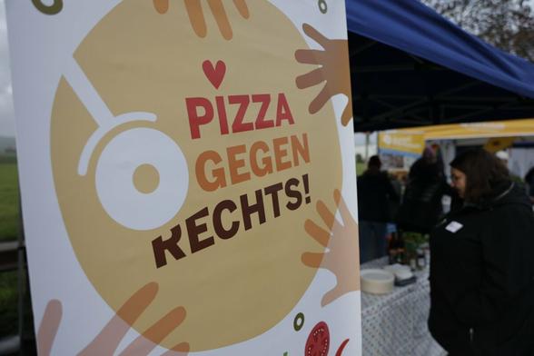 Banner mit der Aufschrift "Pizza essen gegen Rechts".