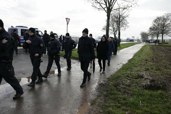 Die Gruppe um Ernst Cran verlässt unter Polizeibegleitung das Mahnmal.