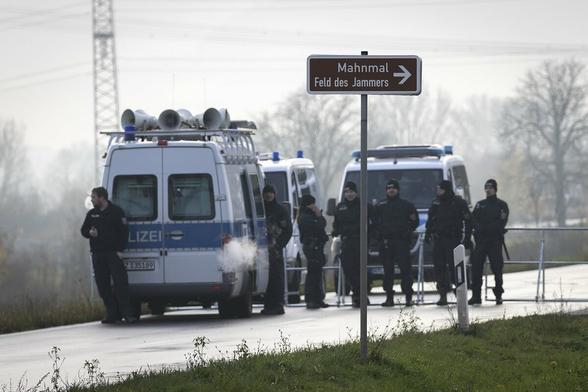 Polizeibeamte sperren mit Gittern die Zufahrtsstraße zum Mahnmal "Feld des Jammers" ab.
