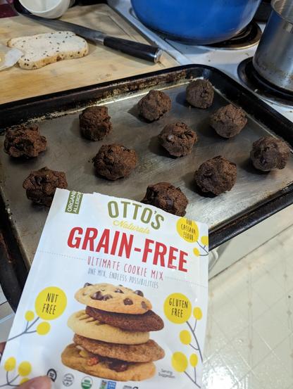 Baking sheet with a dozen cookies ready for the oven. The bag of GF mix from Otto's is in front.