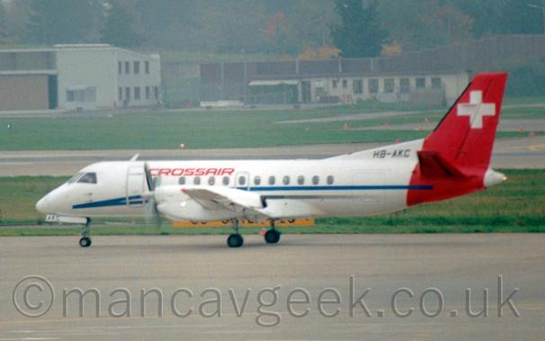 Small propellor airliner with a blue stripe on the fuselage and a large Swiss flag on the tail and rear fuselage.
The fuselage carries "Crossair" titles.