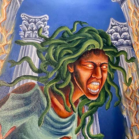 Close up shot of the painting showing Medusa’s face. She has fire glowing inside her eyes and open mouth.
