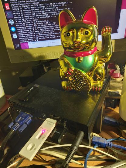 Mini PC mit Winkekatze und dahinter ein Monitor