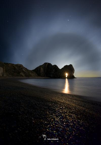 Full moon rise through the arch of Durdle Door with a spectacular lunar halo...