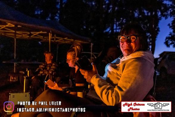 People sitting around a fire on their phones