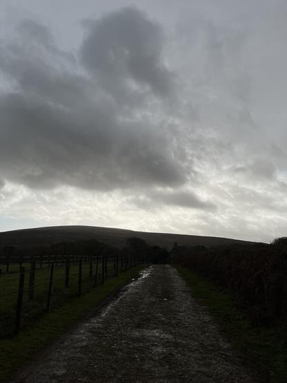 Wet lane looking towards dark moors and sky