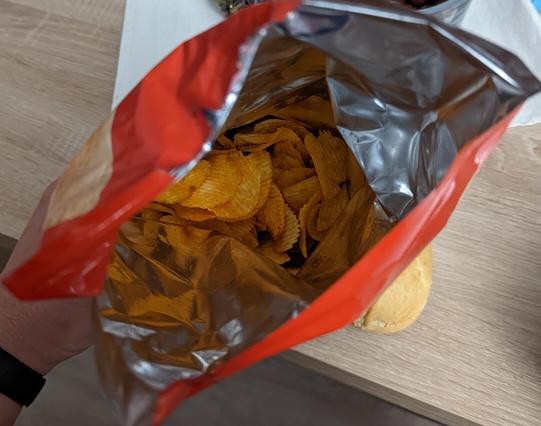 Eine frisch geöffnete Tüte Paprikachips, die mehr Luft als Chips enthält.