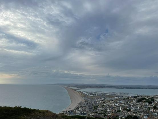 View from Portland over Chesil Beach. Cloudy skies and ocean.