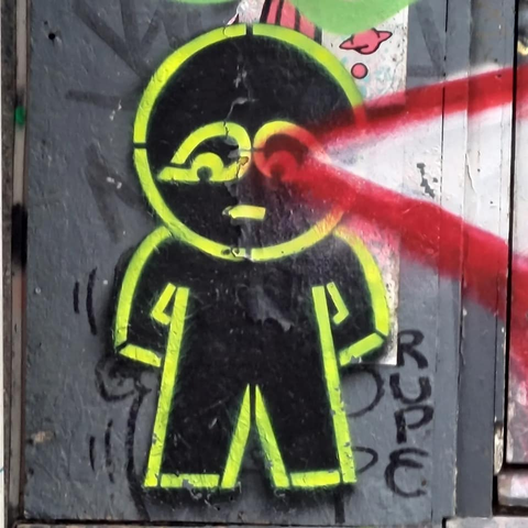 Outlines of a human in neon yellow graffiti