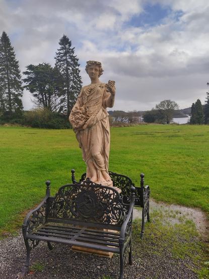 Statue of a goddess with lake in the background at Kilronan Castle in Ireland