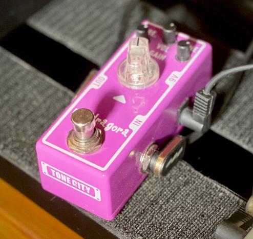 This is a photo of the Tone City Mandragora overdrive pedal on my pedal board.

It's a mini pedal. There are three mini pots visible at the top: Pre, Vol and Tone. Below that, a regular-sized know labeled Gain.

It takes a 9v input on the right-hand side of the pedal.

And yes, it really is quite a shocking pink in real life under strong light!