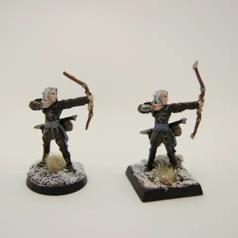 Two elven archers in leathers amid snowy and rocky terrain