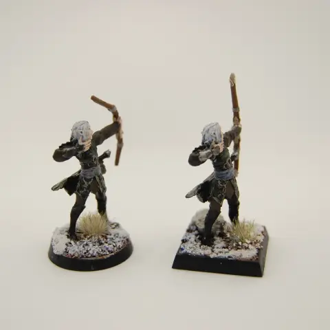 Two elven archers in leathers amid snowy and rocky terrain