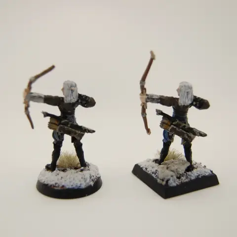 Two elven archers in leathers amid snowy and rocky terrain