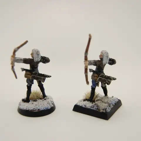 Two elven archers in leathers amid snowy and rocky terrain
