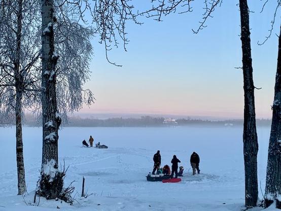 Folks ice fishing in Alaska