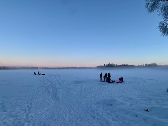 Folks ice fishing in Alaska