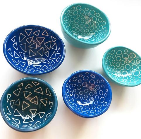 Collection of small pinch pots in blues, turqoise and teal decoratd inside with geometric patterns.