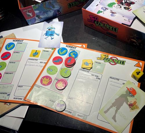 Ausgebreitetes Kinder-Rollenspiel "So nicht, Schurke" mit Charakterbogen, Attributschips und Monsterkarten.