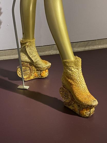 Pale beaded booties with intricately hand carved wooden platform soles.