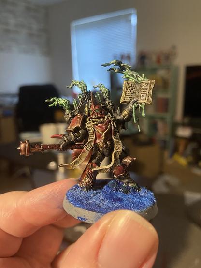 Chaos space marine dark apostle holding a book wreathed in green flame