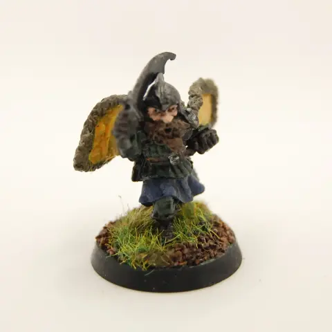 A painted miniature of a dwarf flourishing a cape and brandishing a sabre.