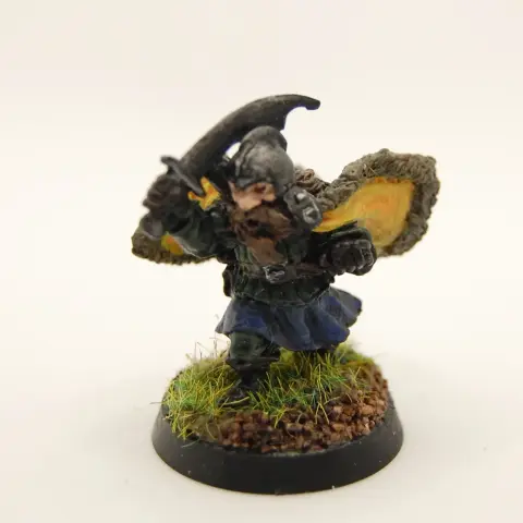 A painted miniature of a dwarf flourishing a cape and brandishing a sabre.