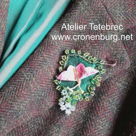 Badge made with green felt on a kilt needle. Paper Art butterfly and flowers made with French perlage.