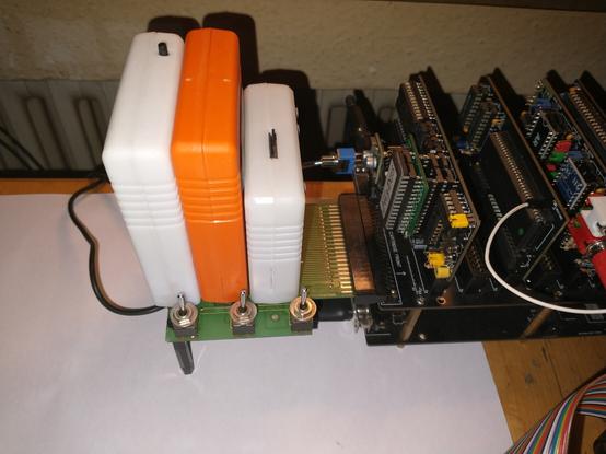 Photo of a Commodore 64 "Cartridge Port Expander"  featuring three cartridge slots. The slots are equipped with (left to right): 2MB NeoRam memory expansion, CynthCart Synthesizer, Kung Fu Flash. Each slot has a switch which will either enable or disable the slot and thus the cartridge plugged into it.