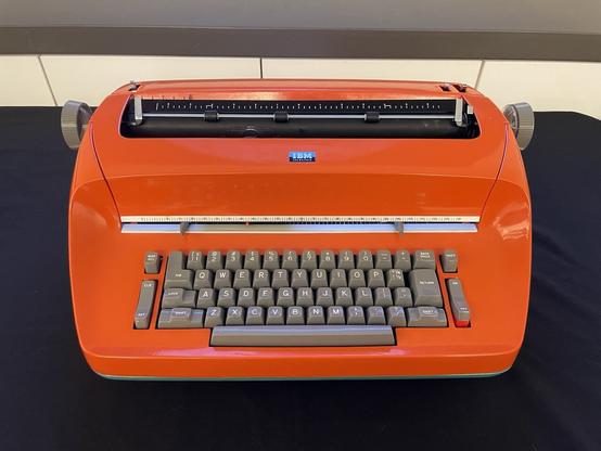 A bright orange IBM Selectric typewriter