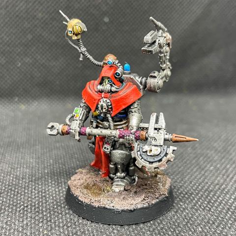 A Tech Priest Enginseer of the Adeptus Mechanicum on a muddy base