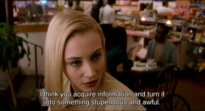 Image from the film Cosmopolis. Sarah Gadon is in a café, head and shoulders visible, facing someone off-screen to the right. She says, 'I think you acquire information and turn it into something stupendous and awful.' She wears a cream-coloured jacket, and her hair is blonde and straight. The café scene behind her is out of focus.