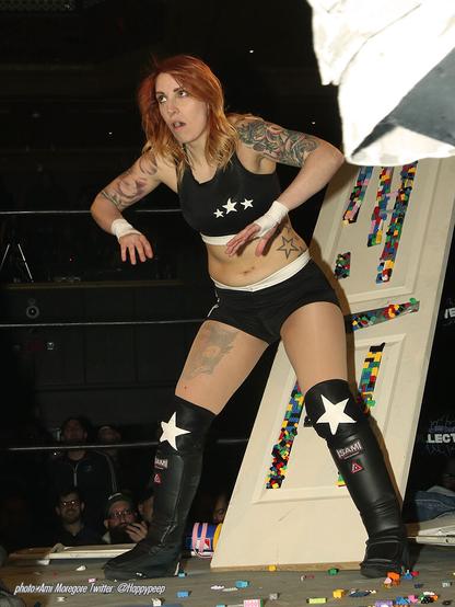 Then Interspecies Wrestling champion Addy Starr stands in front of a door covered with legos in 2019