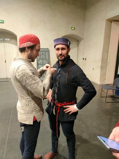 Deux reconstituteurs sont en train d’enfiler leurs habits.