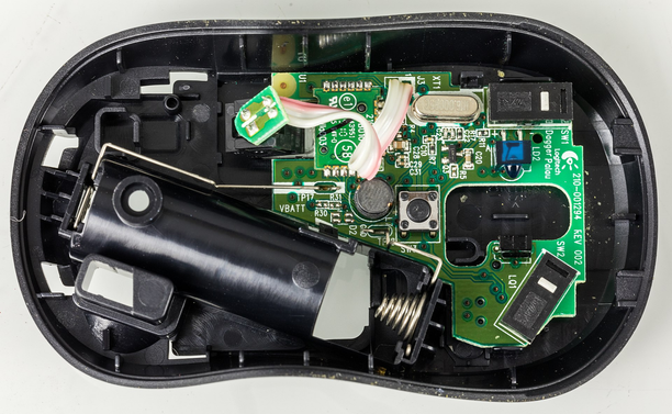 Oberteil der Computermaus entfernt: Links der Batterieschact, rechts die Platine