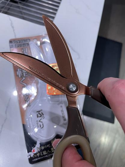 Splayed open scissors highlighting longer top cutting edge