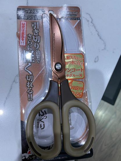 A pair of Nakabayashi Hikigiri scissors lying on top of its packaging