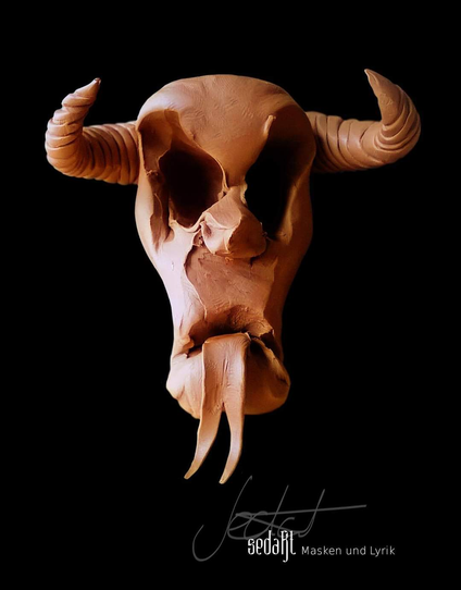 Portrait from plasticine: face of a demon, sticking it's tongue out