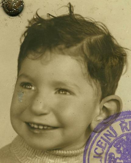 A smiling boy with disheveled dark hair.