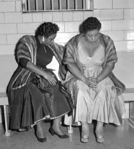 Singer Ella Fitzgerald sits with a woman friend on a bench in a jail after being detained for singing to an integrated audience in 1955.