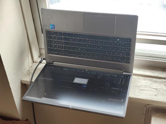HP Book laptop set with it's bottom against an open window.