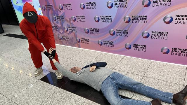 Aaron play acting being dragged away by a squid game character
