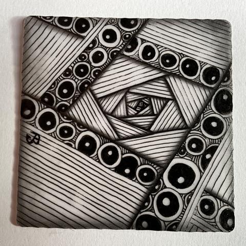 Zentangle abstract art done on a translucent tile. Black lines drawn with a sakura ink pen, with circular dots filling in some of the larger lines. Graphite shading added to give a 3D effect
