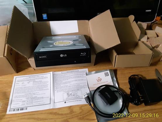 Newly-opened boxes with computer hardware: an LG M-Disc Blu-Ray drive, and a USB adapter kit.