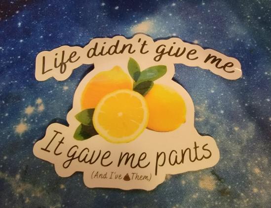 Sticker reading "Life didn't give me (picture of lemons) it gave me pants and I (poop emoji) them" on a galaxy mat background.