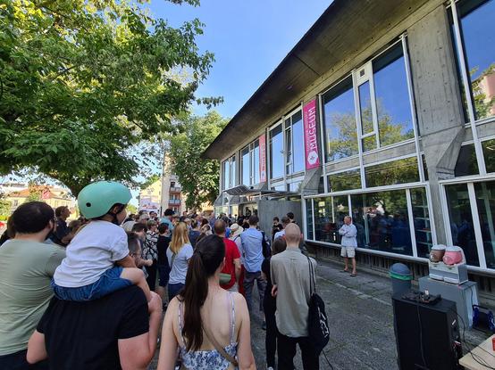 Množica ljudi pred vhodom v stavbo Računalniškega muzeja v Ljubljani