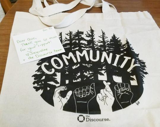 Thank you note & tofe bag with original art, supporter swag from The Discourse, independent community media.  It says COMMUNITY on it.  Design has trees & some sign language.