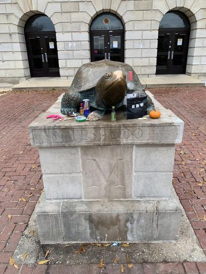 A statue of Testudo at University of Maryland. Students have left sundry items in front of the statue as offers before final exams.