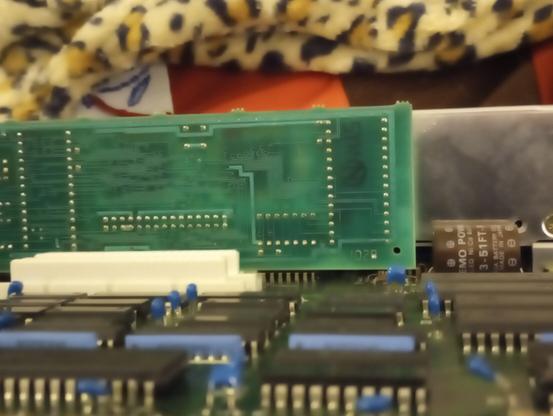 Weird angled pic of tandy 600 motherboard, showing the memory backup nicar battery with a hopefully findable part number